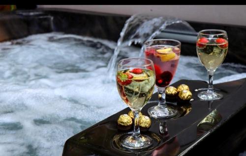 three wine glasses on a tray with a fountain at HotTub-Nature-FamilyFriendly-WiFi-Parking in Ballykelly