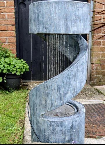 a water fountain in front of a building at HotTub-Nature-FamilyFriendly-WiFi-Parking in Ballykelly