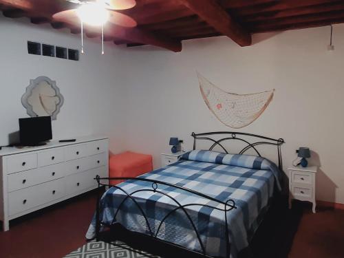 a bedroom with a bed and a dresser at Casa Adua in Donoratico