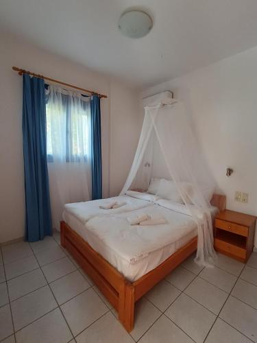 a bedroom with a bed with a canopy at Finikas Studios & Apartments - Kalamaki Holidays in Kalamaki