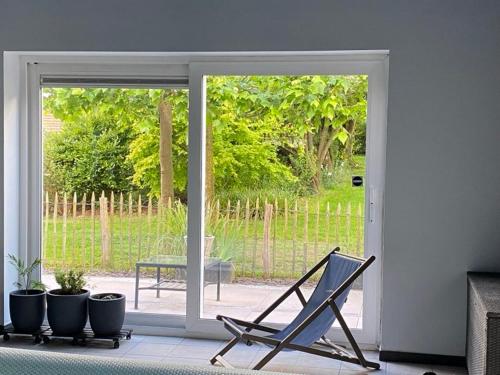 a rocking chair in a living room with a sliding glass door at La Couette de l'Ours in Aywaille