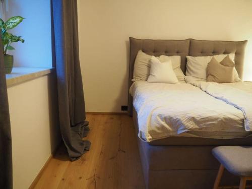 a bed with white pillows in a room with a window at Häuschen im Ortskern in Perg