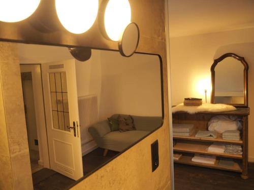 a mirror in a room with a couch and a chair at Häuschen im Ortskern in Perg