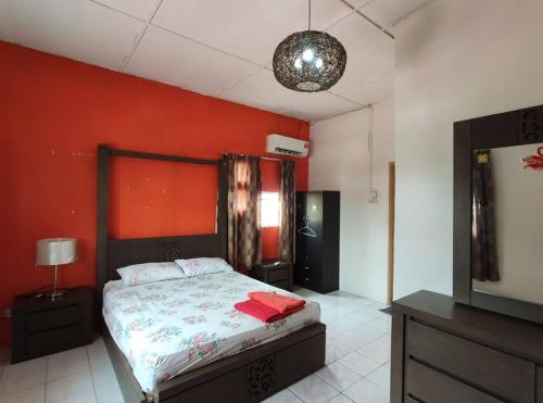 una camera da letto con un letto e una parete rossa di Balinese Villa at Seri Kembangan12 to15 pax a Seri Kembangan