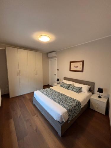 1 dormitorio con 1 cama grande y armarios blancos en Dimora Rosé, en Alba