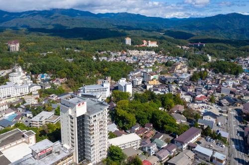 an aerial view of a city with mountains in the background at Hotel Sakurai in Kusatsu