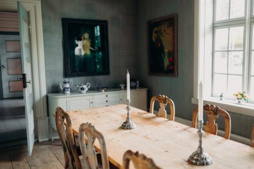 un tavolo da pranzo con due candele sopra di Skrivergaarden - ei historisk perle a Løkja