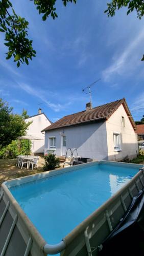 une grande piscine devant une maison dans l'établissement Gîte Unique Le Caijonet proche de Disneyland, Aeroport CDG, Paris, à Villeparisis