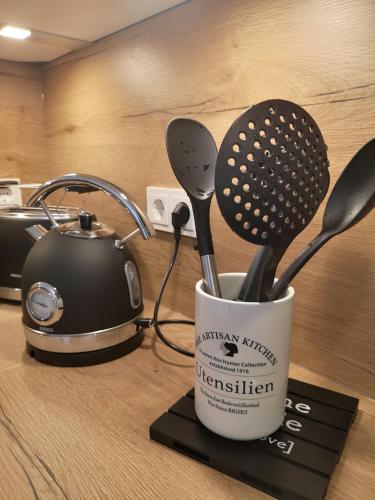 a cup filled with utensils sitting on a counter at Apartment Blicksüd in Unterburg am Klopeiner See