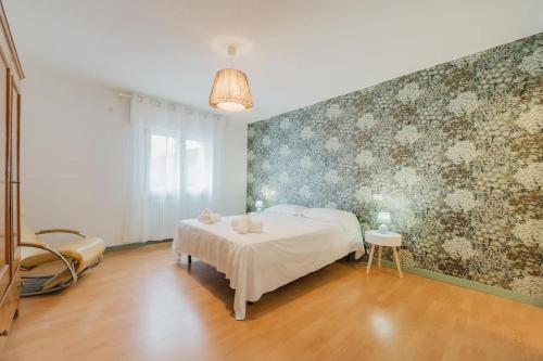 ein Schlafzimmer mit einem Bett und einer Wand mit Blumentapete in der Unterkunft Novalesi Vintage interno 2 in Noale