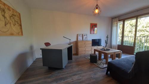 un salon avec un bureau et un canapé dans l'établissement T2 proche gare avec WiFi parking, à Angers