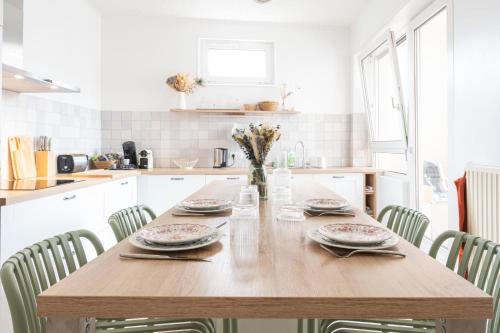 a wooden table in a kitchen with chairs at Ulsibé in Schiltigheim
