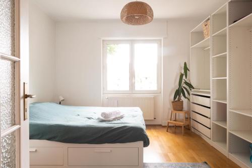 - une chambre avec un lit, une fenêtre et des étagères dans l'établissement Ulsibé, à Schiltigheim