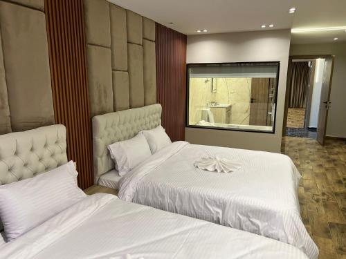 a bedroom with two beds with white sheets at Pyramids Enigma Grand Lodge in Cairo