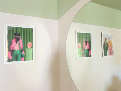 a mirror in a room with pictures of a cat at Cozy Nest Golem in Golem