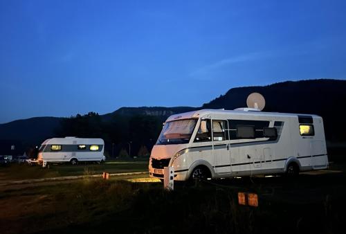 two rvs parked next to each other in a field at Góry Stołowe Camp - Rodzinne pole biwakowe, Kampery, Przyczepy, Namioty in Radków