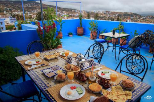 a table with food and drinks on a balcony at Casa Voyager 'secret garden terrace' in Chefchaouene