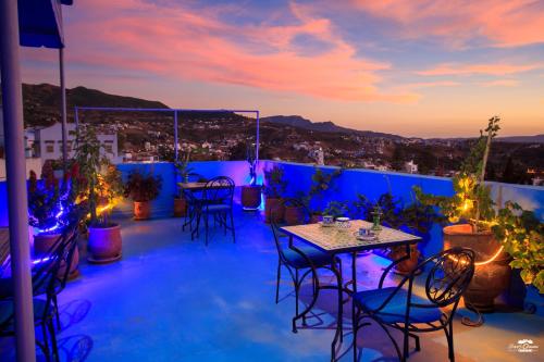 a rooftop patio with tables and chairs at night at Casa Voyager 'secret garden terrace' in Chefchaouene