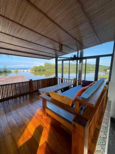 a bedroom with two beds on a deck with a view of the water at Eco Lagoon in Phu Quoc