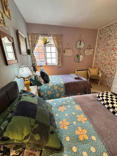a bedroom with two beds and a chair at 4 The Haw thornes Sleeps4 NEC 7mins BHX 8mins in Coleshill
