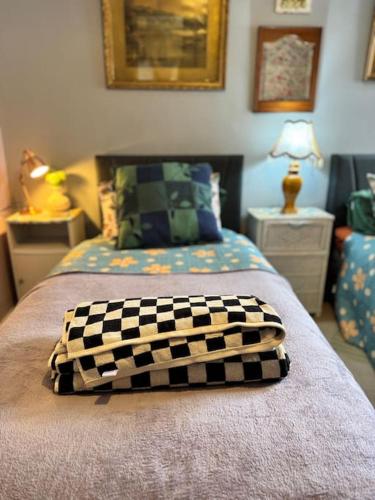 a bed with a checkered blanket on top of it at Two Stylish Apartments Sleeps 10 BHX NEC in Coleshill