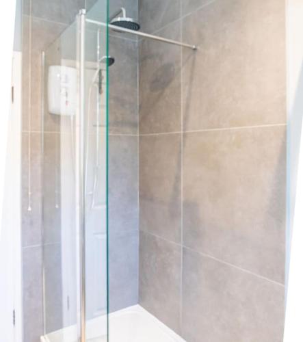 a shower with a glass door in a bathroom at Two Stylish Apartments Sleeps 10 BHX NEC in Coleshill