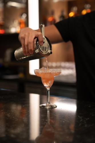 a person pours a drink into a martini glass at Home2 Suites by Hilton Fort Walton Beach Eglin AirForce Base in Fort Walton Beach