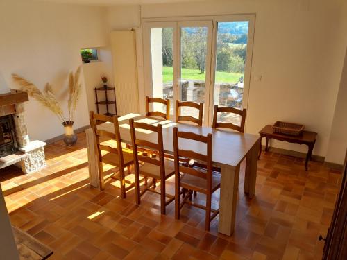 une salle à manger avec une table et des chaises et une cheminée dans l'établissement La cantinière, à Fougerolles