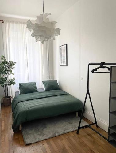 - une chambre avec un lit dans une pièce dotée d'un lustre dans l'établissement Appartement Brunard, à Lyon