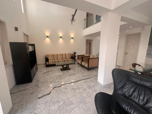 a living room with two couches and a television at Mizzle Exotica Lonavala in Lonavala