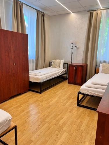 a room with two beds and wooden floors at Klaipeda INN Private Parking and Kitchen in Klaipėda
