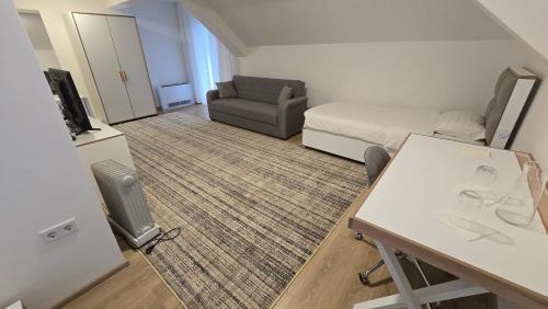 a small living room with a bed and a desk at Potočari Han in Srebrenica