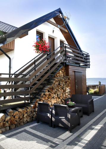 a house with stairs and a pile of logs at Apartamenty 5 metrów od morza in Rewa