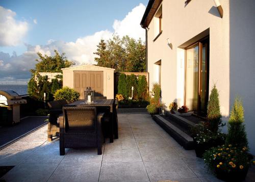 a patio with a table and chairs and a house at Apartamenty 5 metrów od morza in Rewa