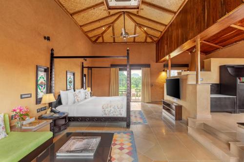 a bedroom with a bed and a living room at AamaGhati Wildlife Resort, Ranthambore in Sawāi Mādhopur