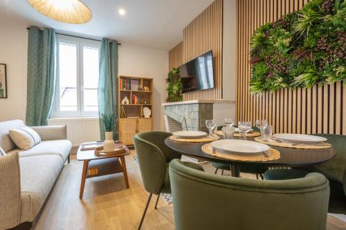 un salon avec une table, des chaises et un canapé dans l'établissement Tropical Escape near city center Fiber Netflix, à Montluçon