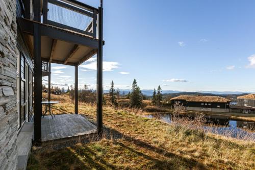 a building with a porch with a train in the background at Naturopplevelser året rundt i Valdres Ski in out Panoramautsikt in Aurdal