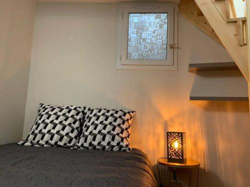 - une chambre avec un lit, une fenêtre et une lampe dans l'établissement Le cocon T2 duplex 24 m2, à Niort