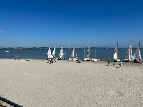 a group of sailboats on a beach with people on it at Apartamenty 5 metrów od morza in Rewa