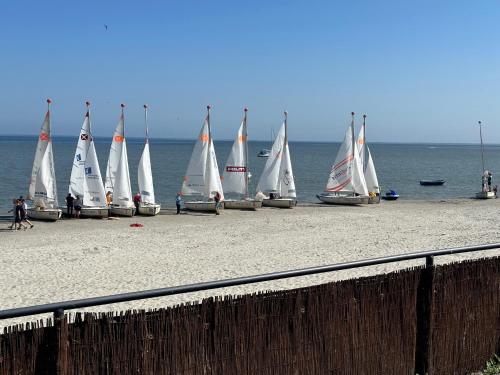 a group of sailboats on a beach near the water at Apartamenty 5 metrów od morza in Rewa