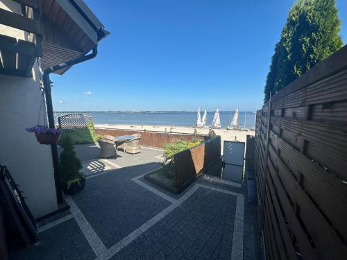 a brick walkway leading to a beach with a fence at Apartamenty 5 metrów od morza in Rewa