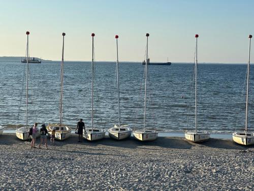 a group of boats are lined up on the beach at Apartamenty 5 metrów od morza in Rewa