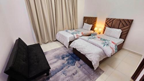 a bedroom with two beds and a table with a lamp at Splendid Villa Rooms near Dubai Airport in Dubai