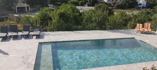 une grande piscine avec des chaises dans l'établissement Bas de villa prestations haut de gamme, à Vallauris