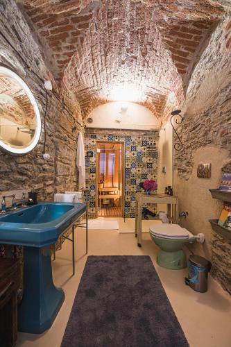 a bathroom with a blue sink and a toilet at Albergo Diffuso Antagonisti in Melle