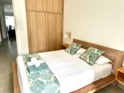a bedroom with a bed with green and white pillows at Beach spot in Riambel