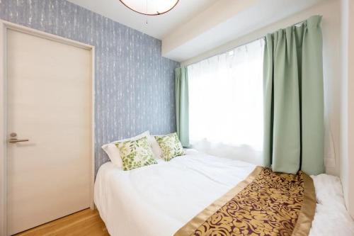 a bedroom with a white bed and a window at 今和Hotel in Tokyo