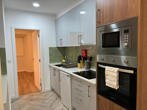 a kitchen with a stove and a microwave at Charming Benavente in Benavente