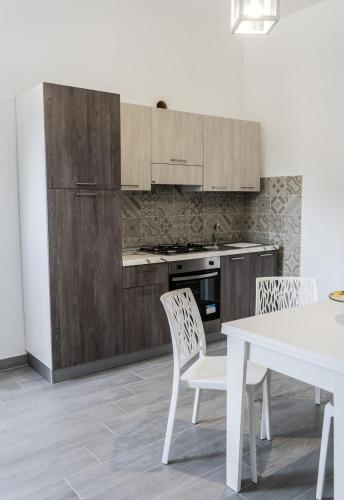 a kitchen with wooden cabinets and a table and chairs at Moon Valley Holiday Home in Lauria