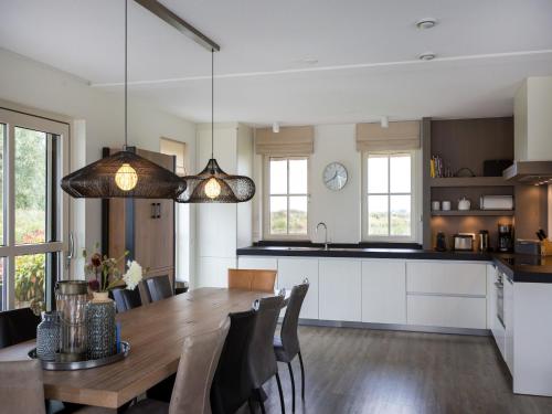 a kitchen and dining room with a table and chairs at Friesland Villa with Fireplace in Delfstrahuizen